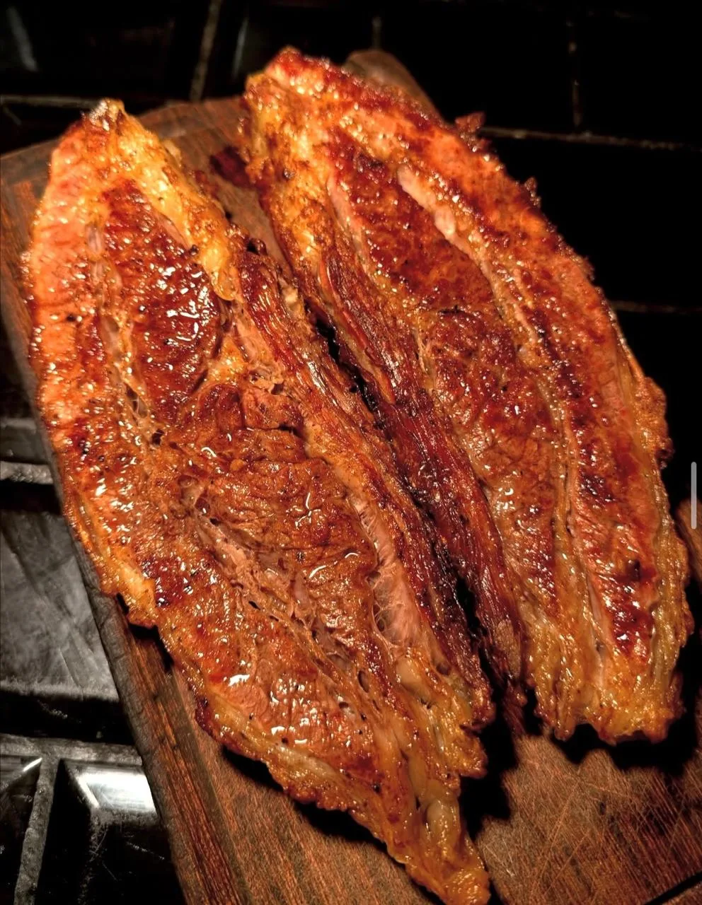 Entrañas doradas a la parrilla servidas en tabla de madera