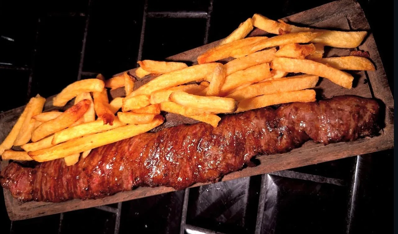 Bife de chorizo a la parrilla con papas fritas en tabla