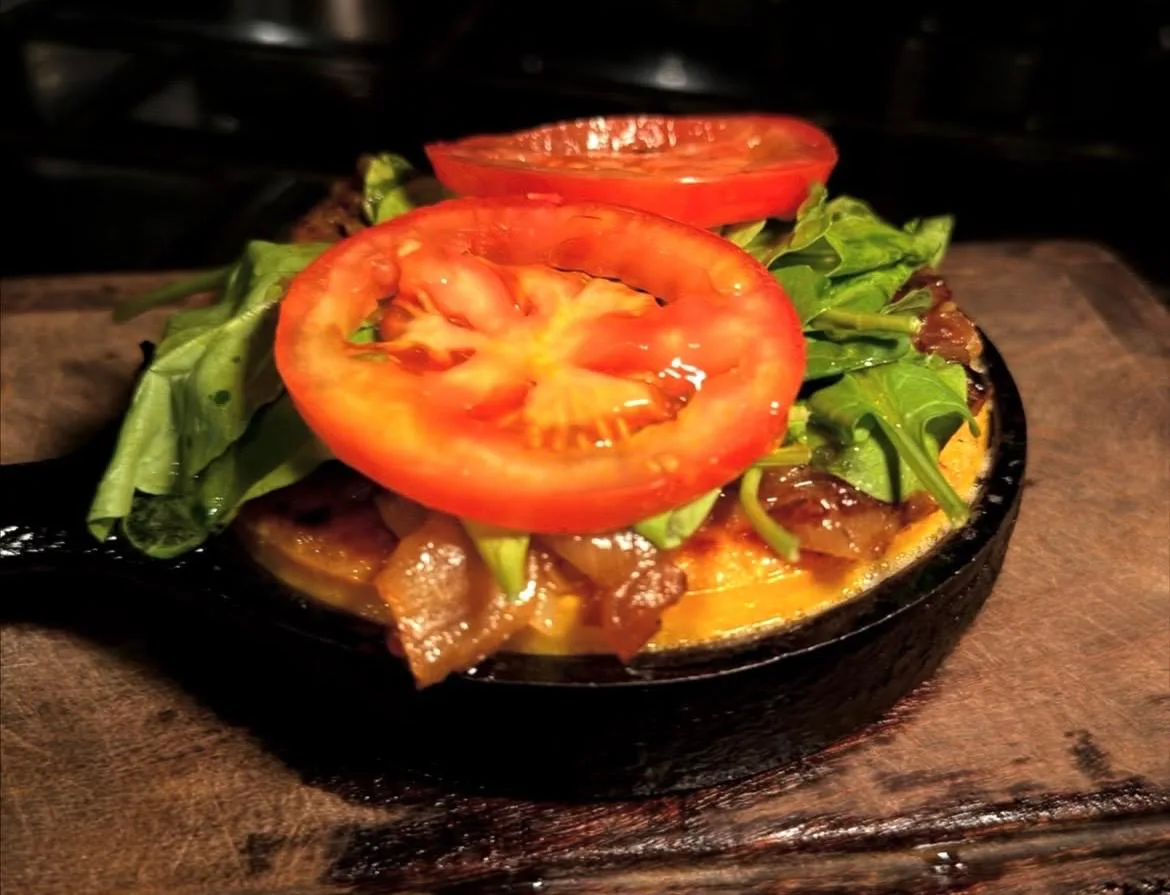 Plato a la parrilla con tomate fresco y rúcula en sartén de hierro